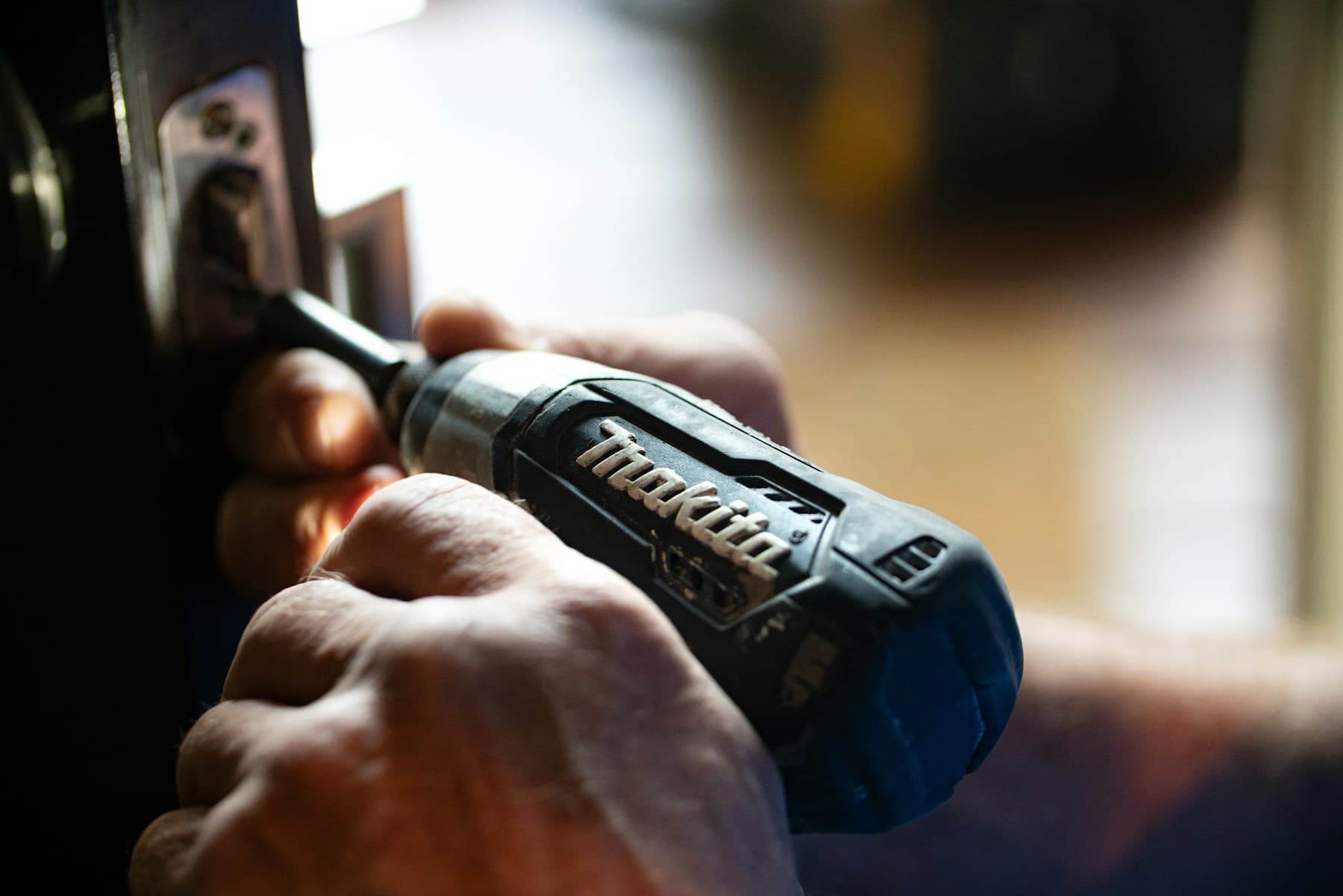 Hands using a power tool during repair work